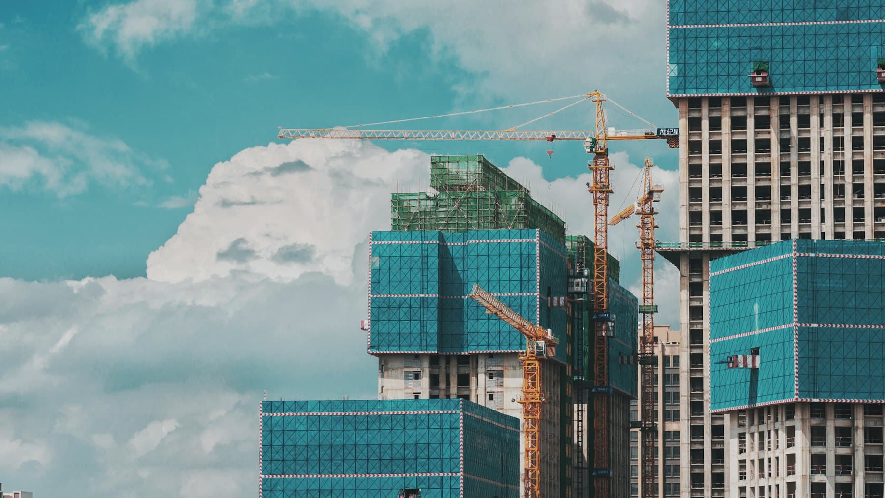 Immeuble de grande hauteur en cours de travaux, grues en toiture